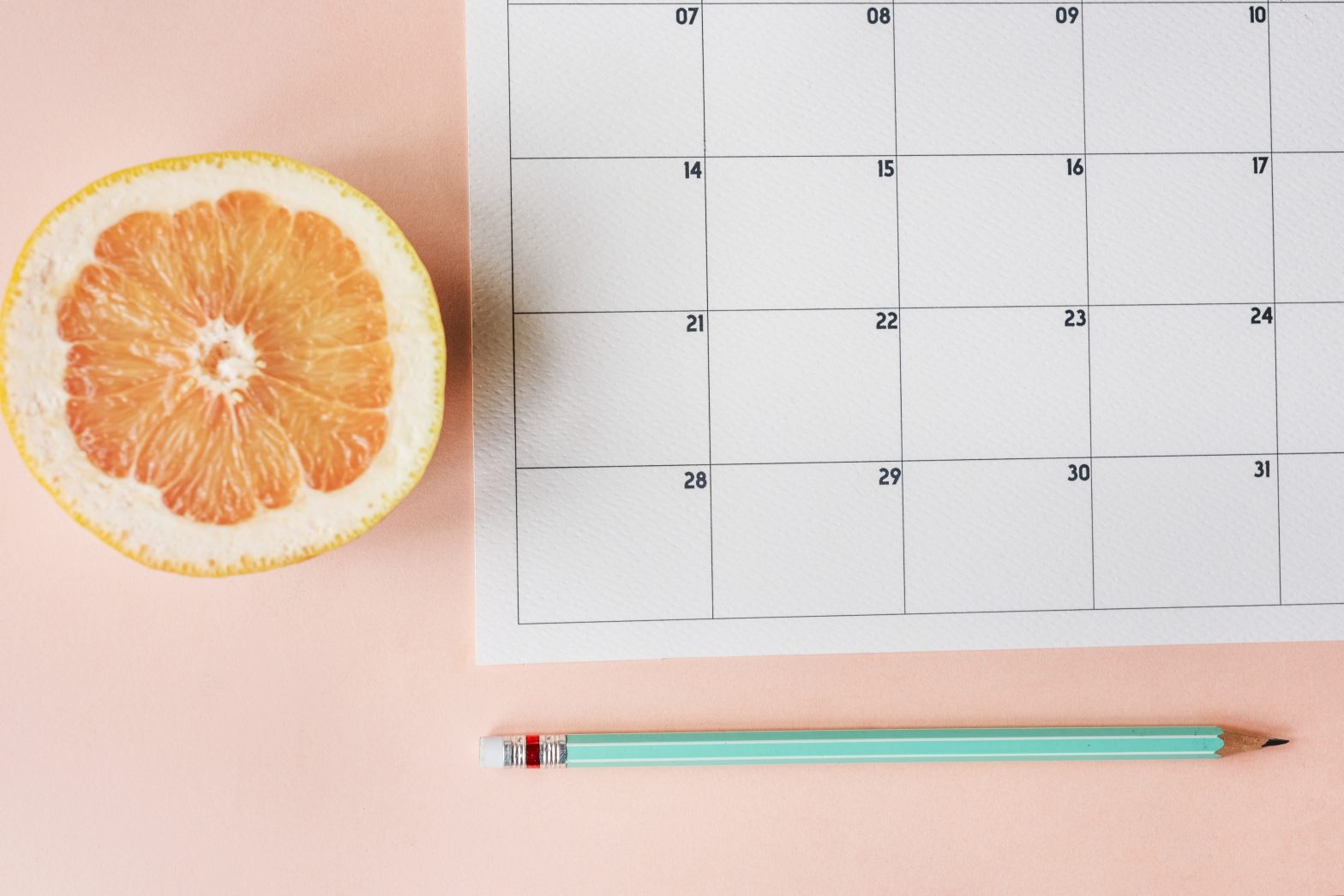 Imagen de un calendario para hacer la organización de tu trabajo y planificación del bullet journal sobre fondo rosa.